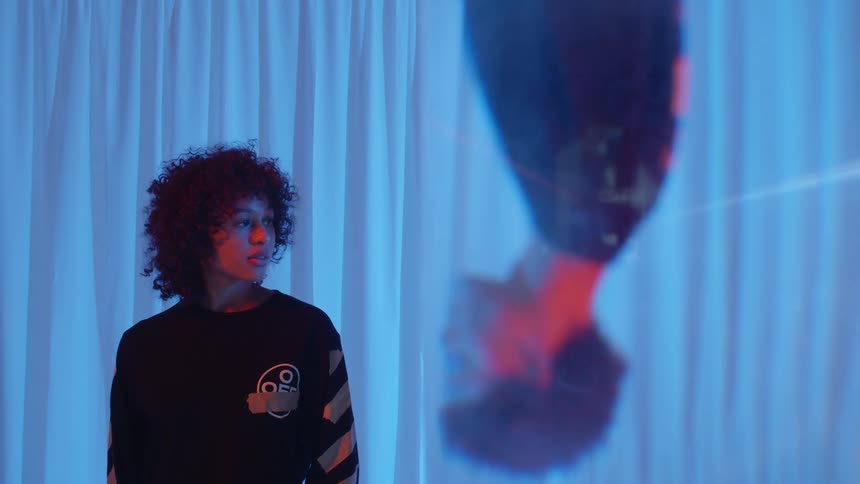 A woman is standing near a curtain indoors