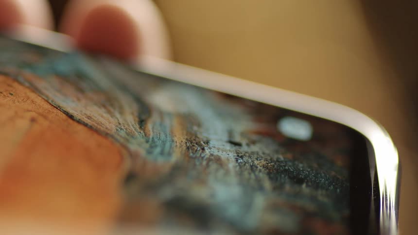 Stylish macro shot of a finger gently tapping the blue send button on a smartphone screen. Captured in cinematic warm light, ideal for illustrating digital messaging, modern communication, UX/UI usability, and mobile app interaction.