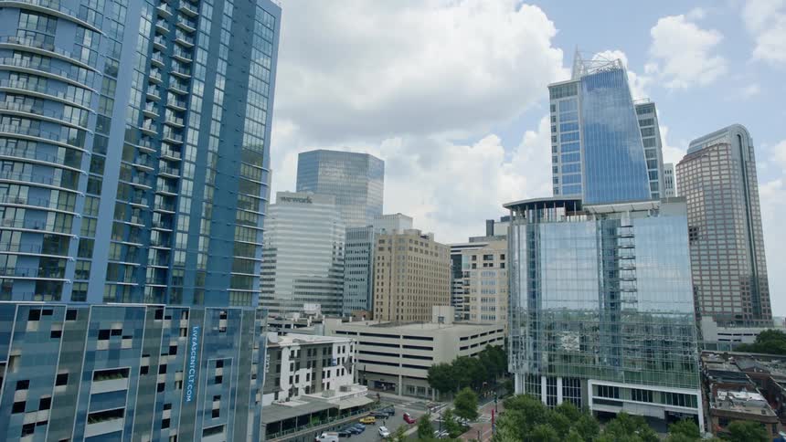 The tall buildings have mirrored windows in the city