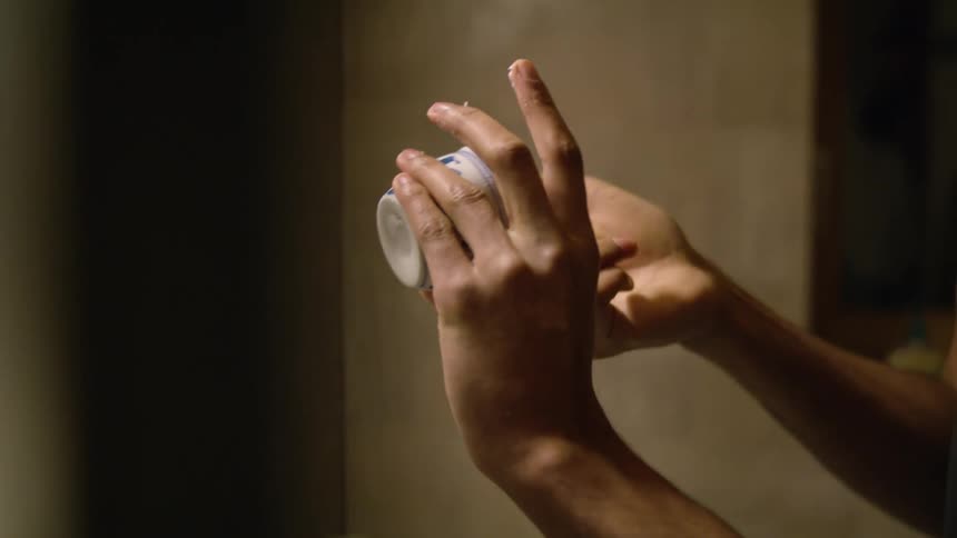 A person is putting cream on their face