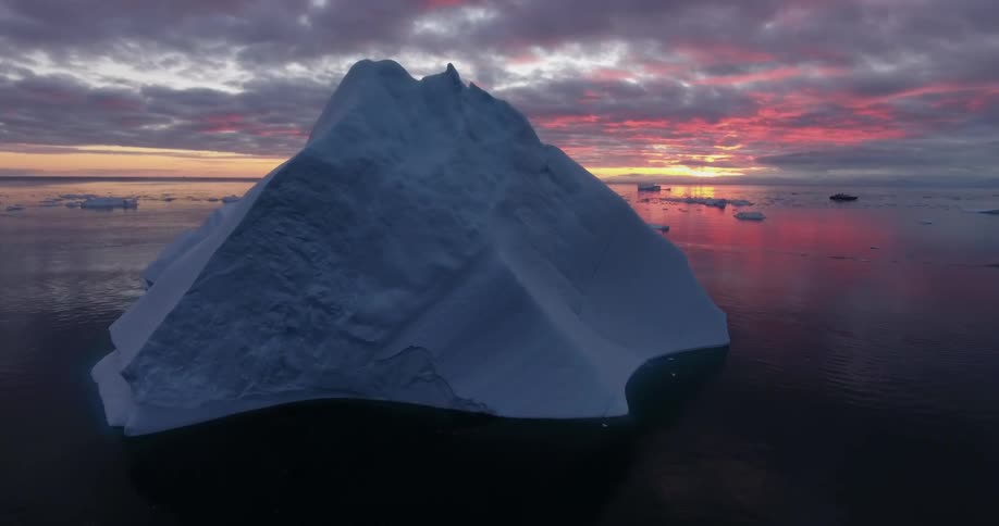 Arctic iceberg under a red cloudy sky
