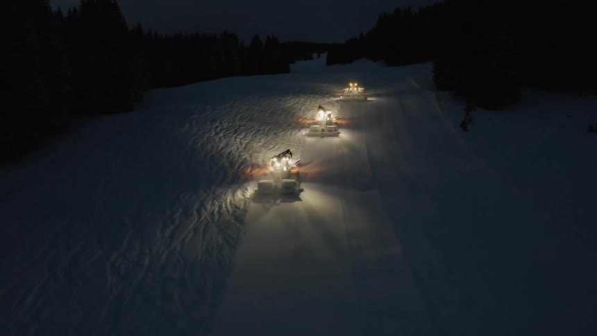 Cars are driving on a road during winter at night