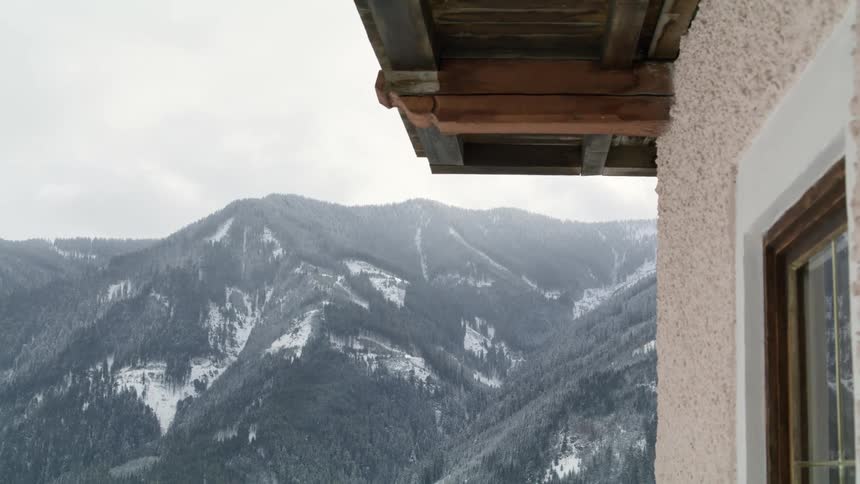 A beige stucco home has views of tall mountain range