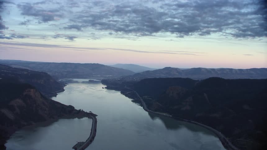 Blue hour aerial looking down the Columbia River Gorge and the Columbia River as the calm water reflects a sunset sky