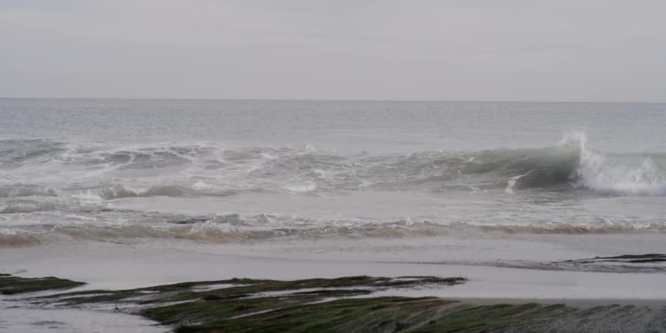 Waves coming ashore on a cloudy day