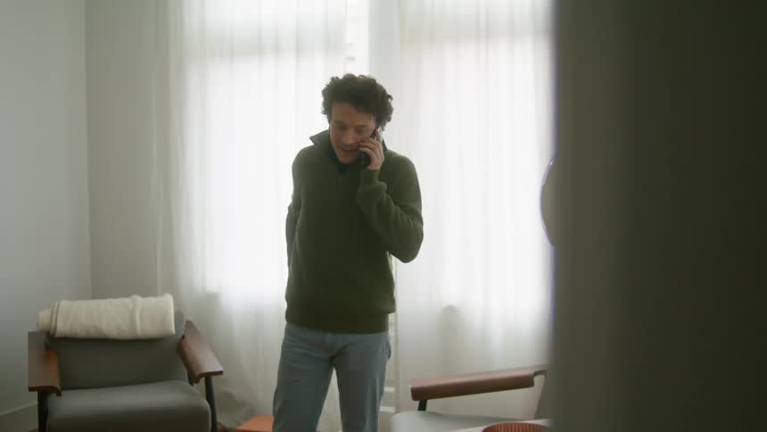 A man is talking on a phone indoors