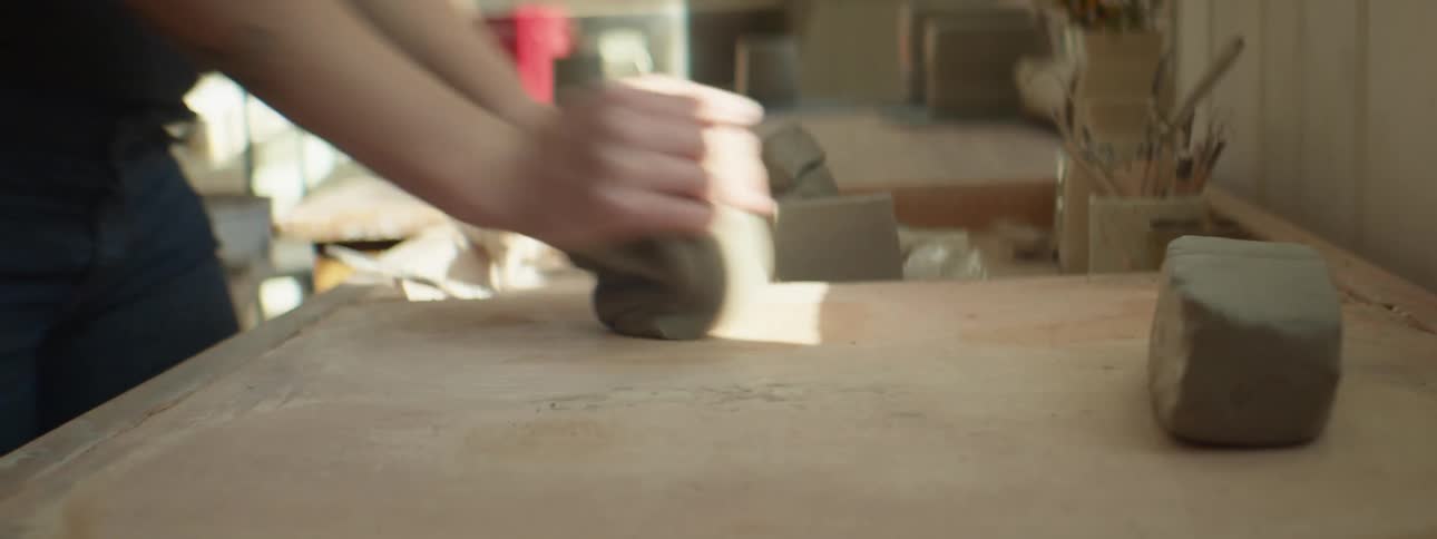 A woman kneading clay
