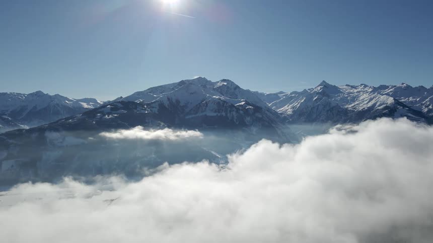 Snow covered mountain range high in the clouds