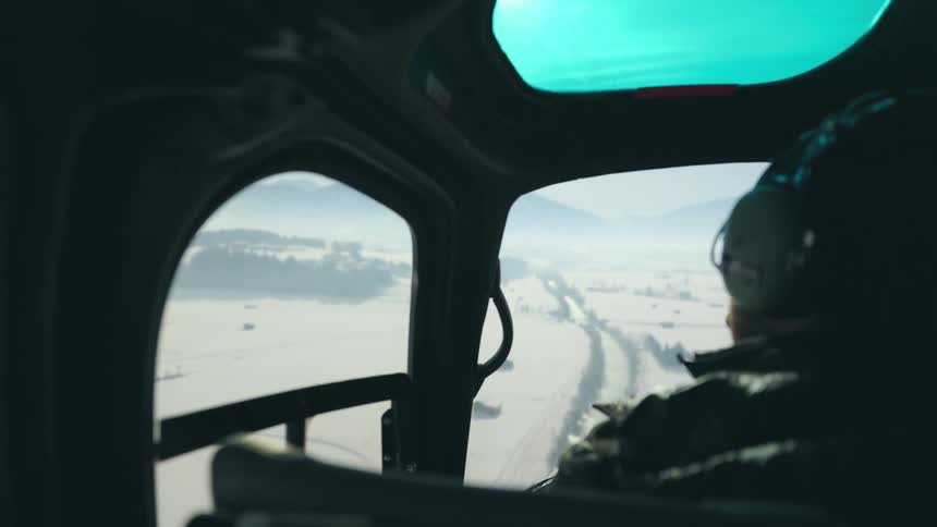 A pilot flying a helicopter in the daytime