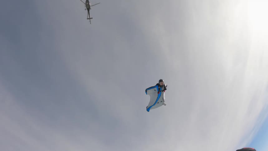 People are wind riding under a helicopter