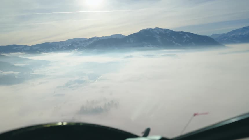 Flying over mountains and clouds in a helicopter