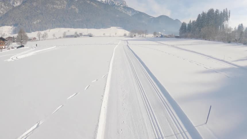 Aerial view of a landing in a snowy field with mountains in the distance