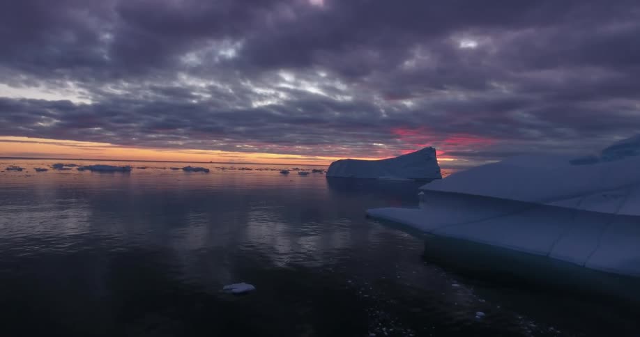 Snow and ice floating on water in the wilderness at dusk