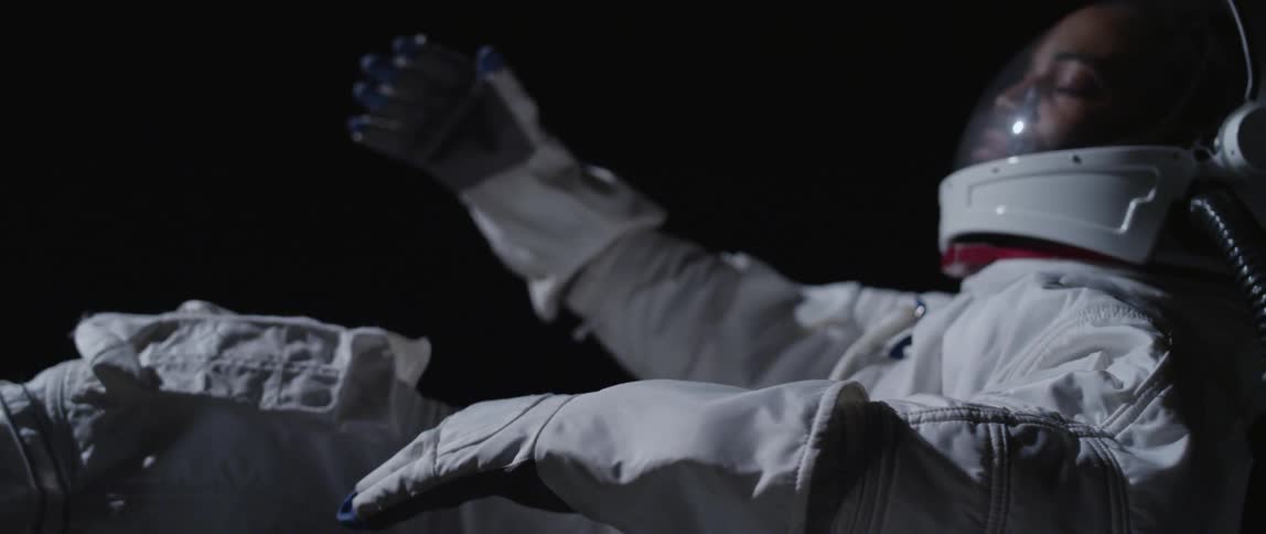 An astronaut is asleep as he floats around