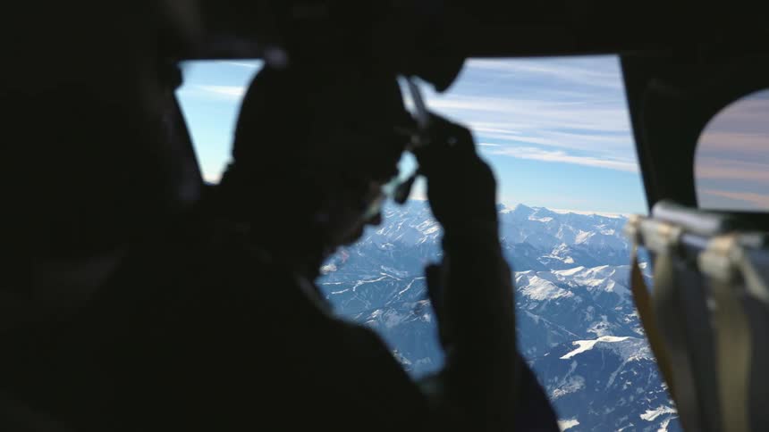 Two men looking out of a helicopter