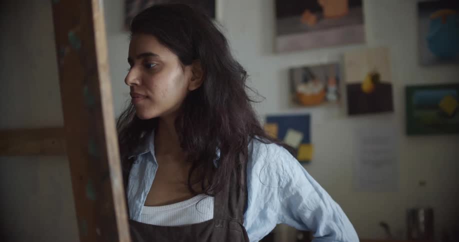 A female artist painting on a canvas in an art studio