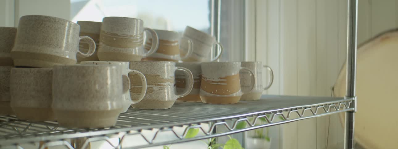 Mugs sitting on a shelf in a warehouse