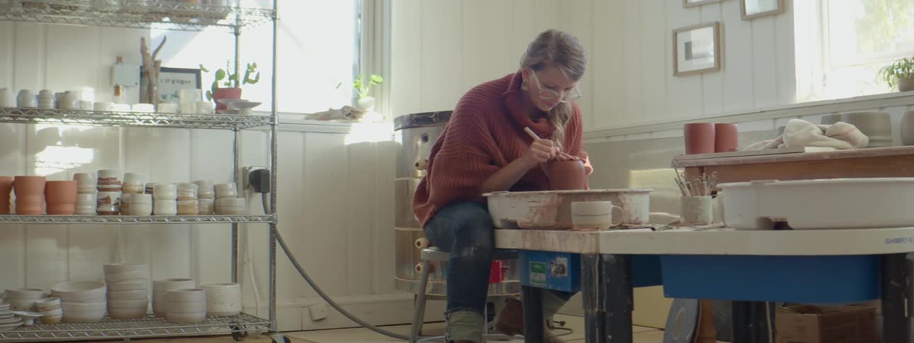 A woman working with clay in a studio