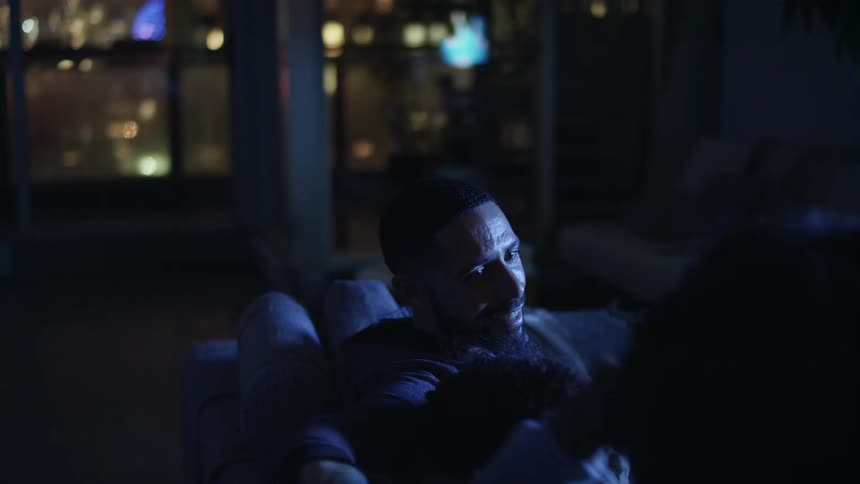 A family sitting on a couch watching tv
