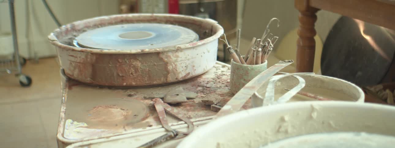 Clay and pottery is displayed on a table indoors