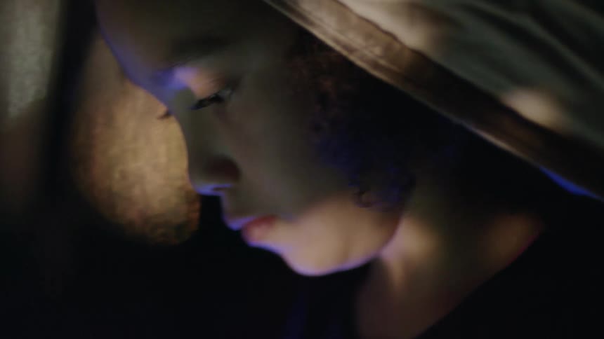A young girl looks at a cell phone