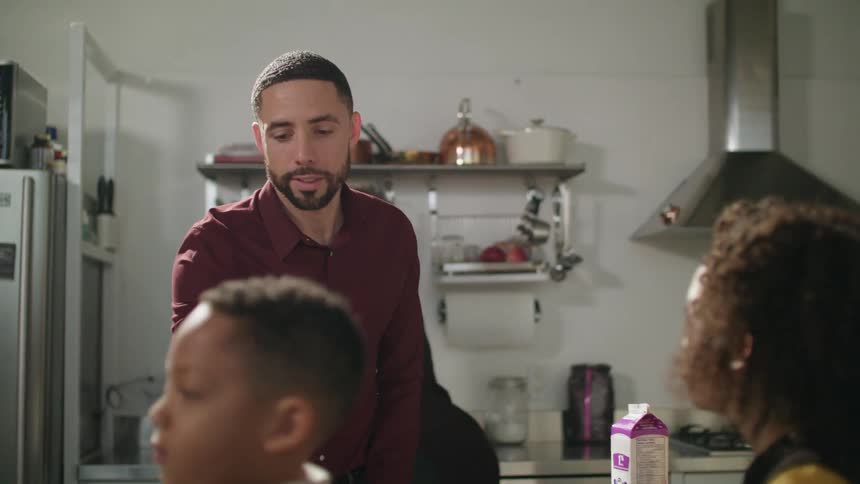 Family of four finishing breakfast in the kitchen at home
