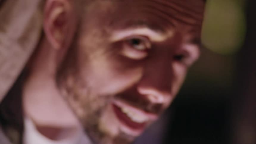 A man is smiling and talking indoors