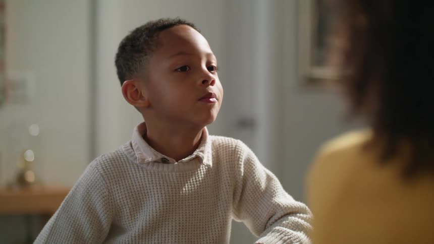 Young siblings talking to each other in the livin groom at home