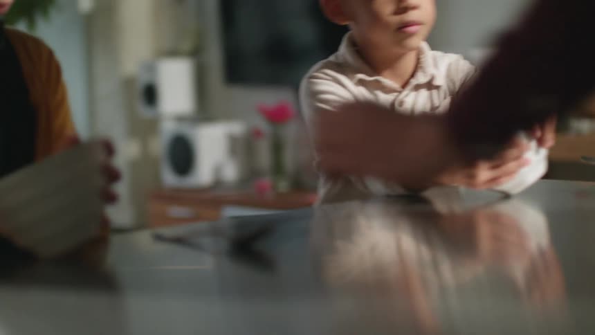 A boy and a girl at a table with a bowl and spoon