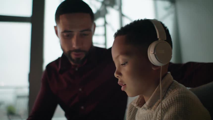 A man talks to his son on the couch