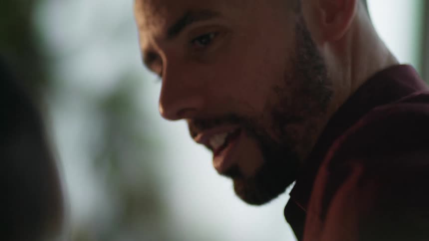 A man is talking while sitting by a window during the day