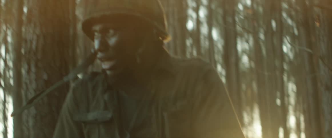 A wounded soldier limps through the forest