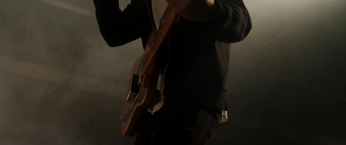 A man on a stage plays a guitar