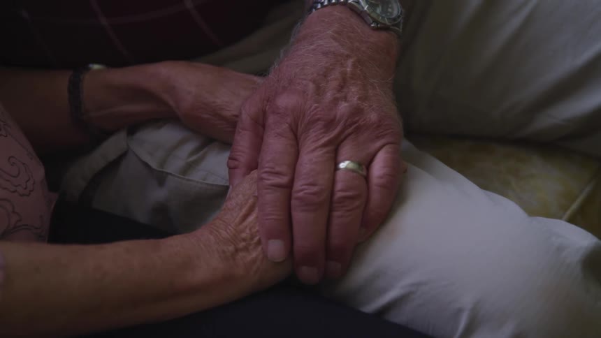 Close up of an elderly couples hands as they hold hands