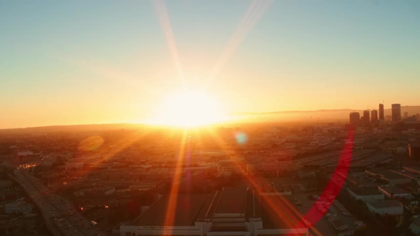 Bright sun and sun flare shines over city