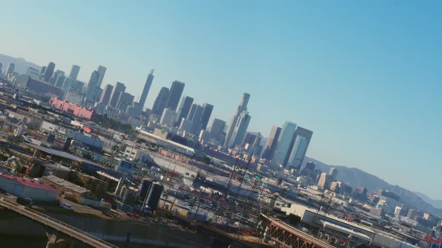 A major metropolitan city skyline can be seen off in the distance and surrounded by industrial buildings