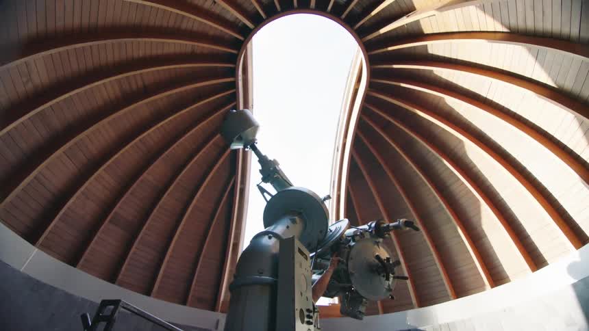 An observatory with a telescope with the roof rotating