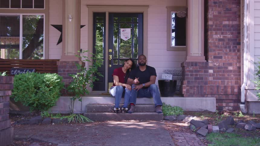 Couple sitting on front porch of their home
