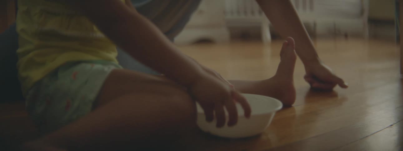 Mother and daughter sitting on the wooden floor of the bedroom at home