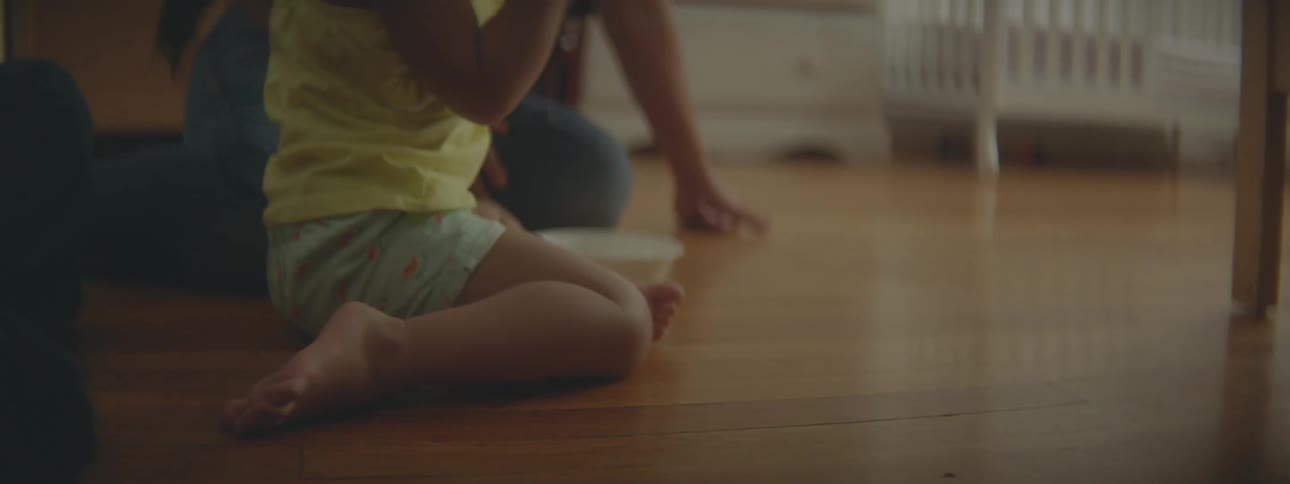 A woman sits on the floor of her daughters bedroom with her