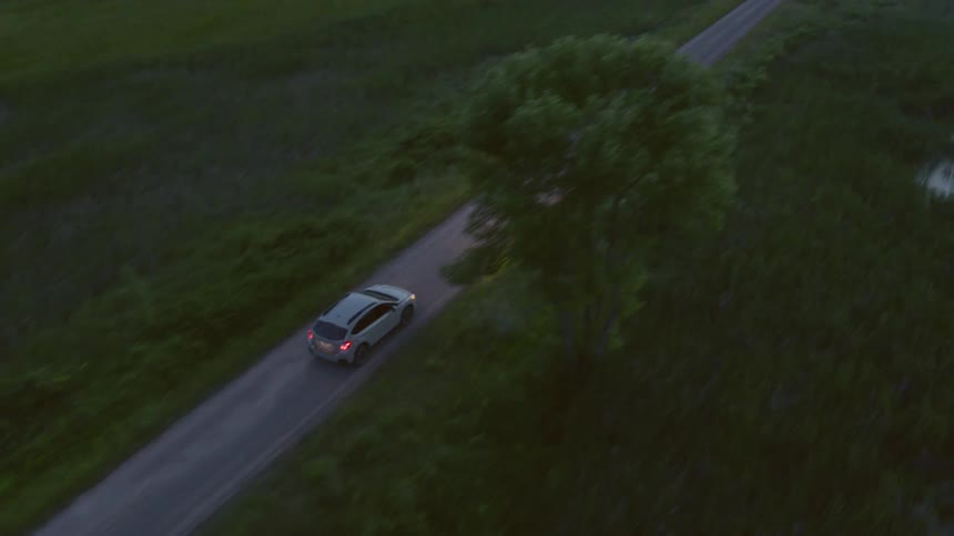 A car driving down a road at dusk