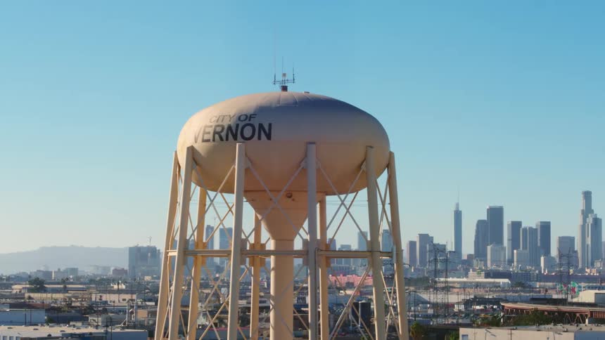 A water tower in front of a city skyline