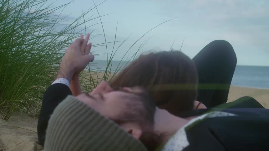 A couple rest together on the beach