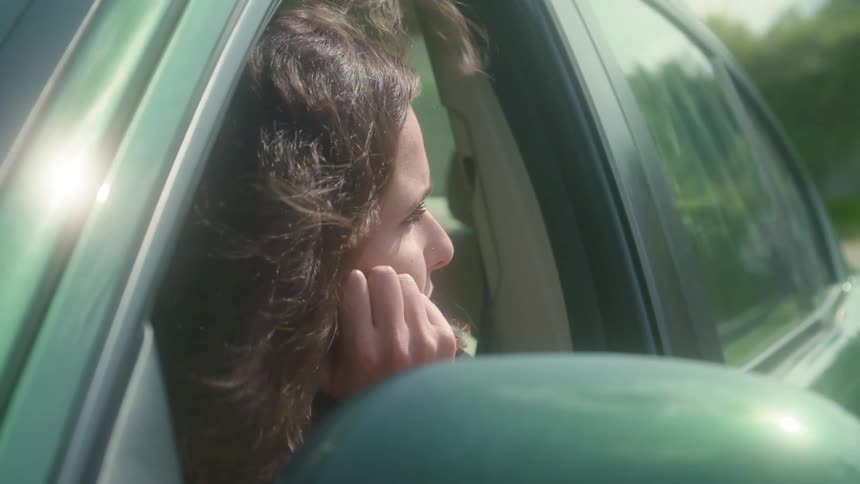 A woman is sitting in a car during spring