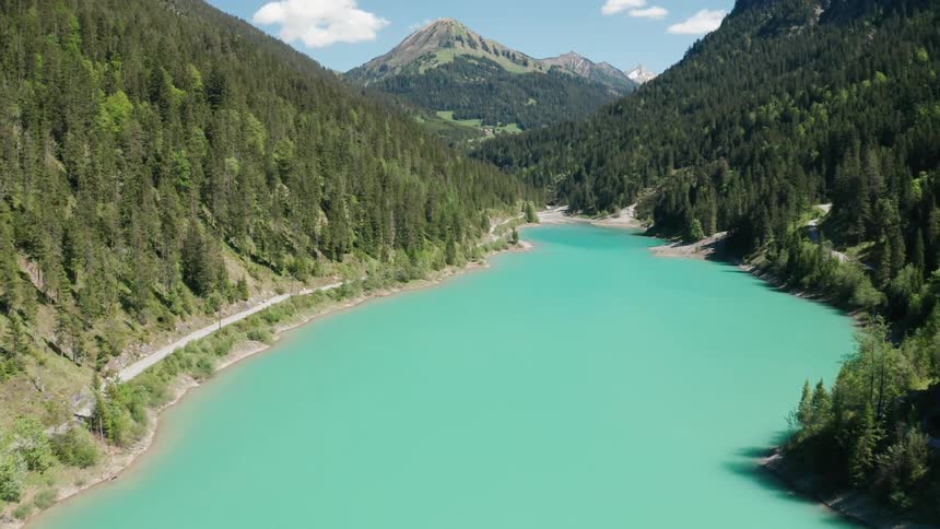 River with forested mountains on each side and a mountain in the distance