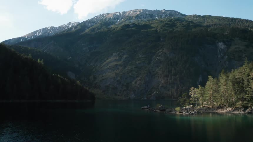 Lake with a forest on the coast and a huge mountain