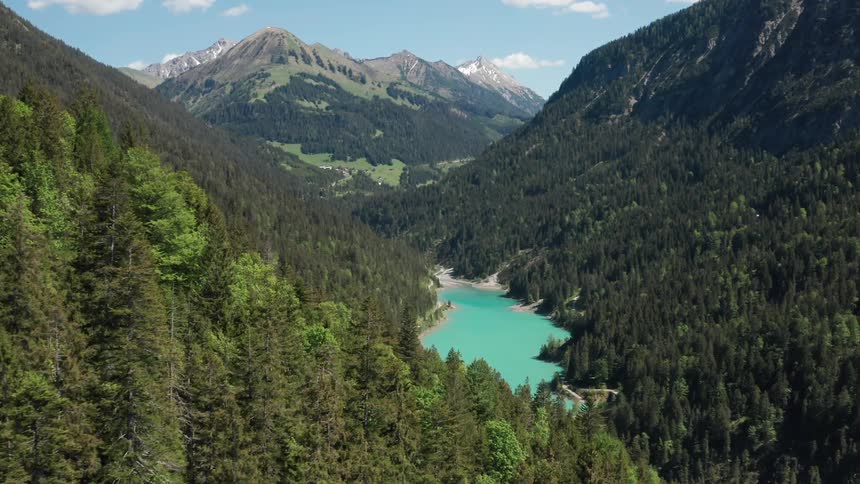 Tarn lake between forested mountains