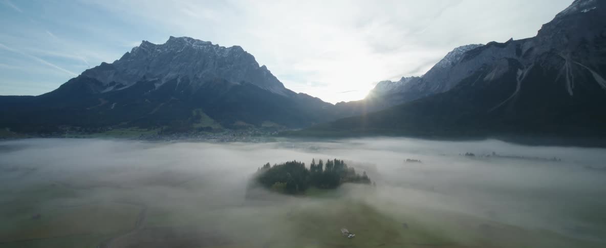 A landscape view of fog at the base of a mountain range