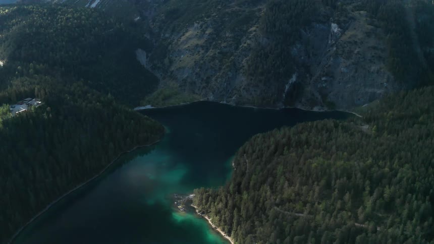 Aerial view of the pristine waters of a lake in a valley between the mountains