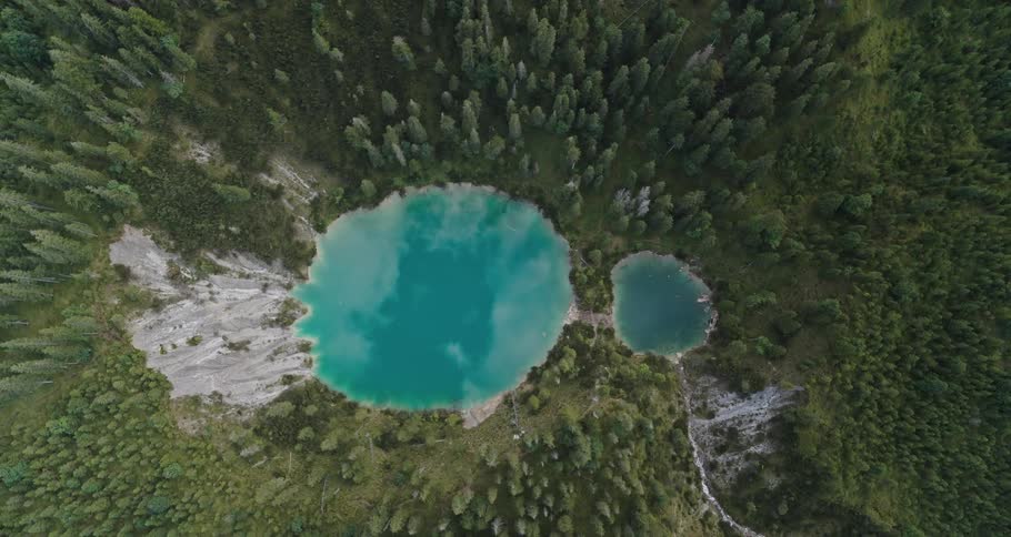 A large caldera lake and a small caldera lake with forest all around
